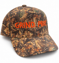 Woodland camouflage cap with orange Grind.Pray. embroidery and a curved brim